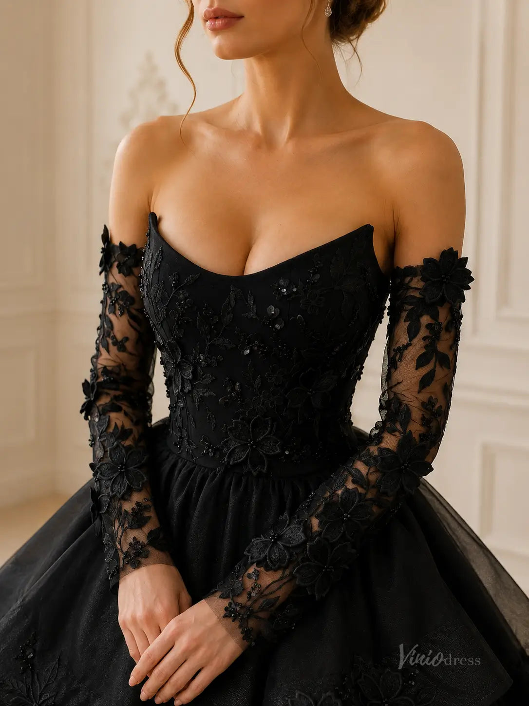 Black strapless ball gown with intricate floral lace embroidery, sequin details, and matching sheer long sleeves.