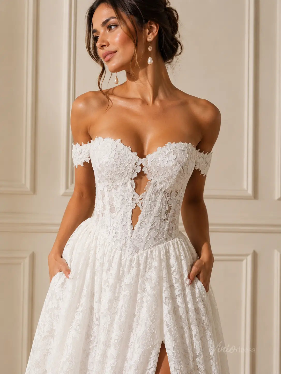 White off-the-shoulder lace wedding dress with a sweetheart neckline, corset bodice, and side pockets.