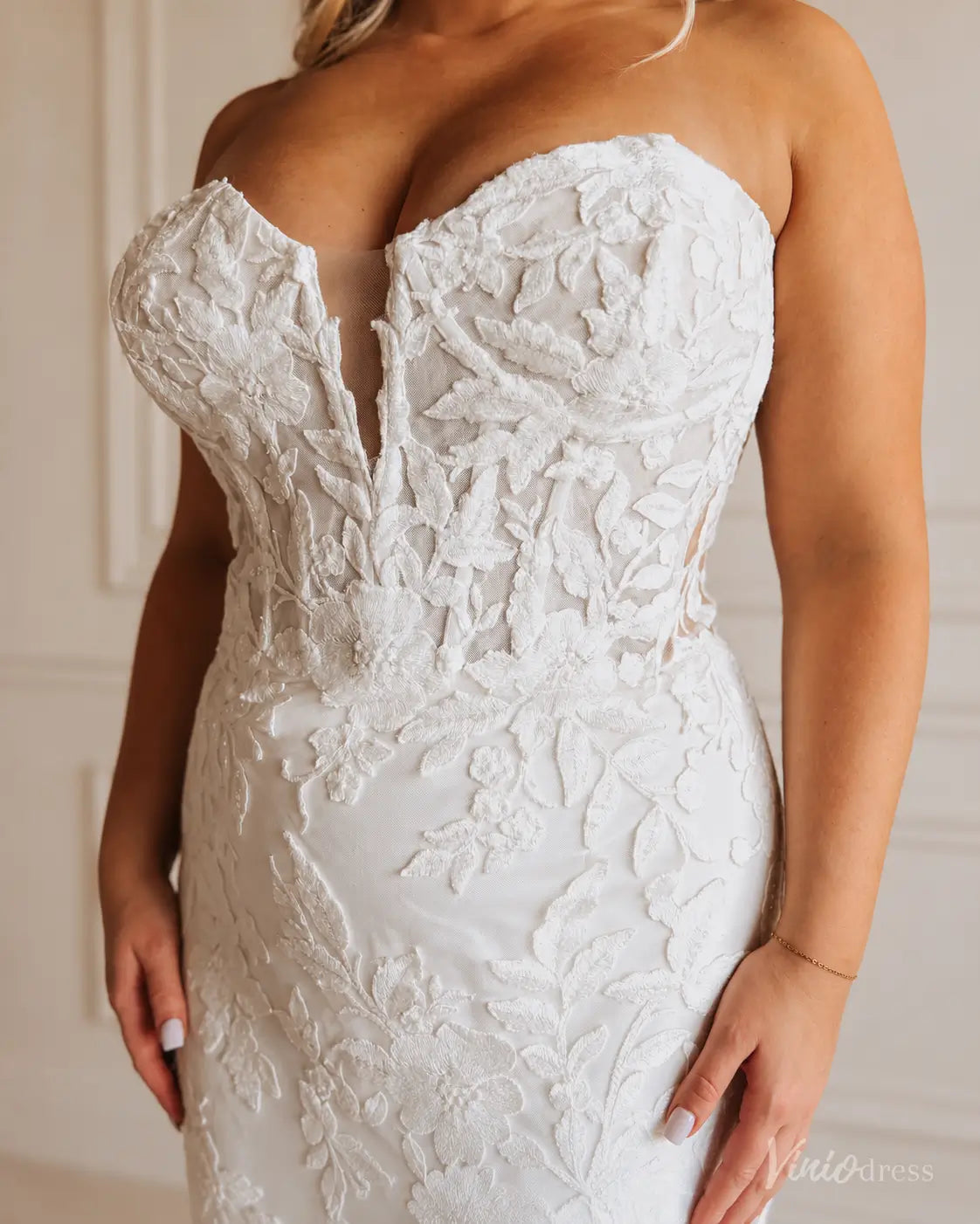 ML201 strapless white bridal gown with a sweetheart neckline, sheer plunge detail, and intricate floral lace overlay.