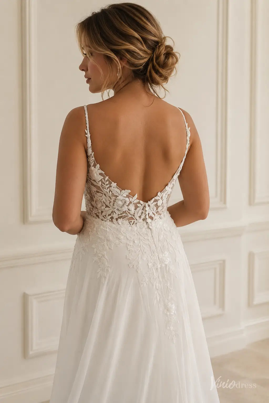 White bridal gown LA181 featuring a low back, delicate floral lace bodice, thin straps, and a flowing chiffon skirt.