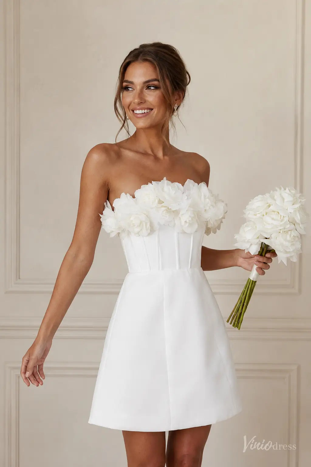 White strapless mini wedding dress with a structured corset bodice and handcrafted 3D floral neckline.