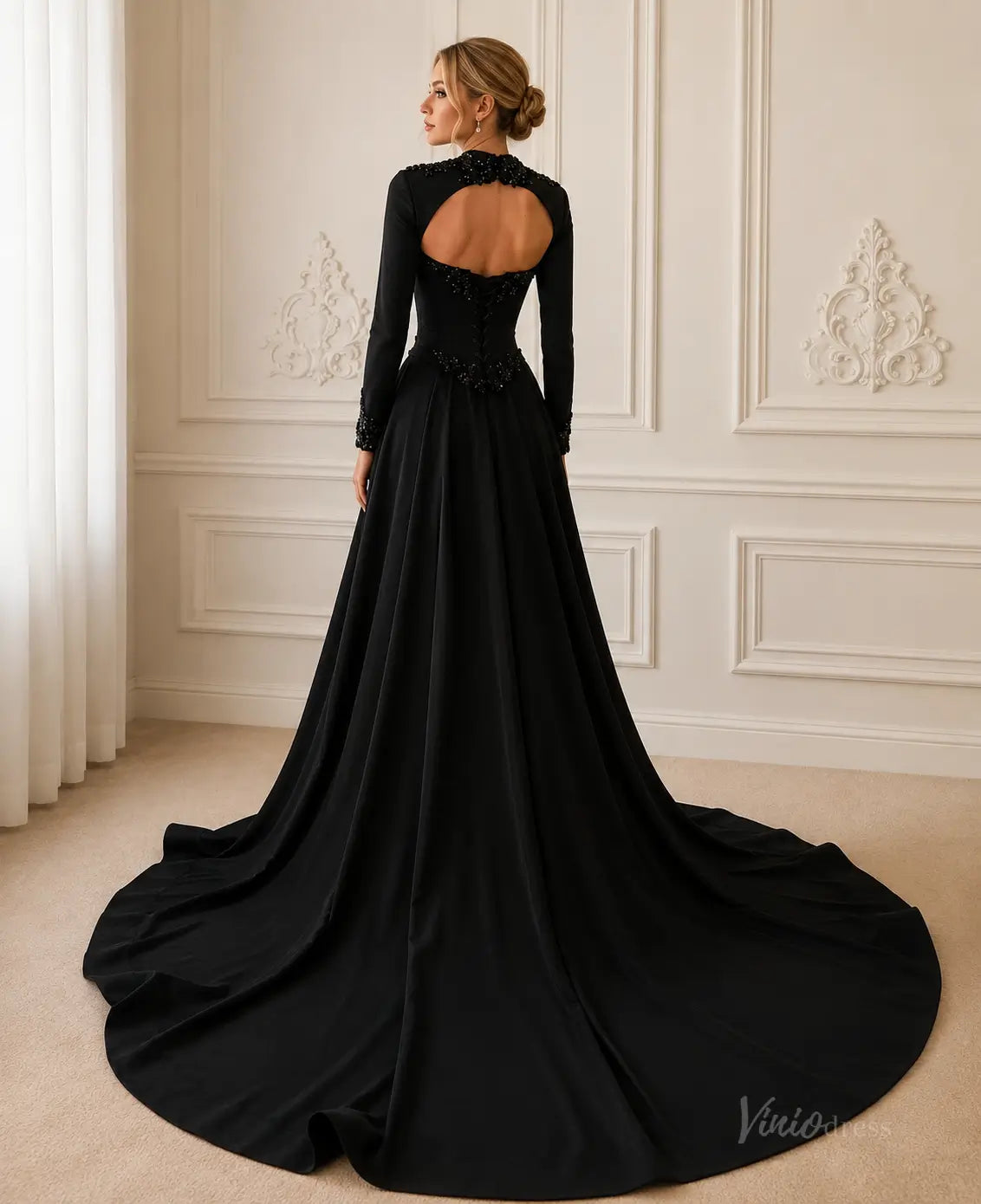 Black long-sleeve crepe gown with a beaded high neck, open back, and a dramatic floor-length train.