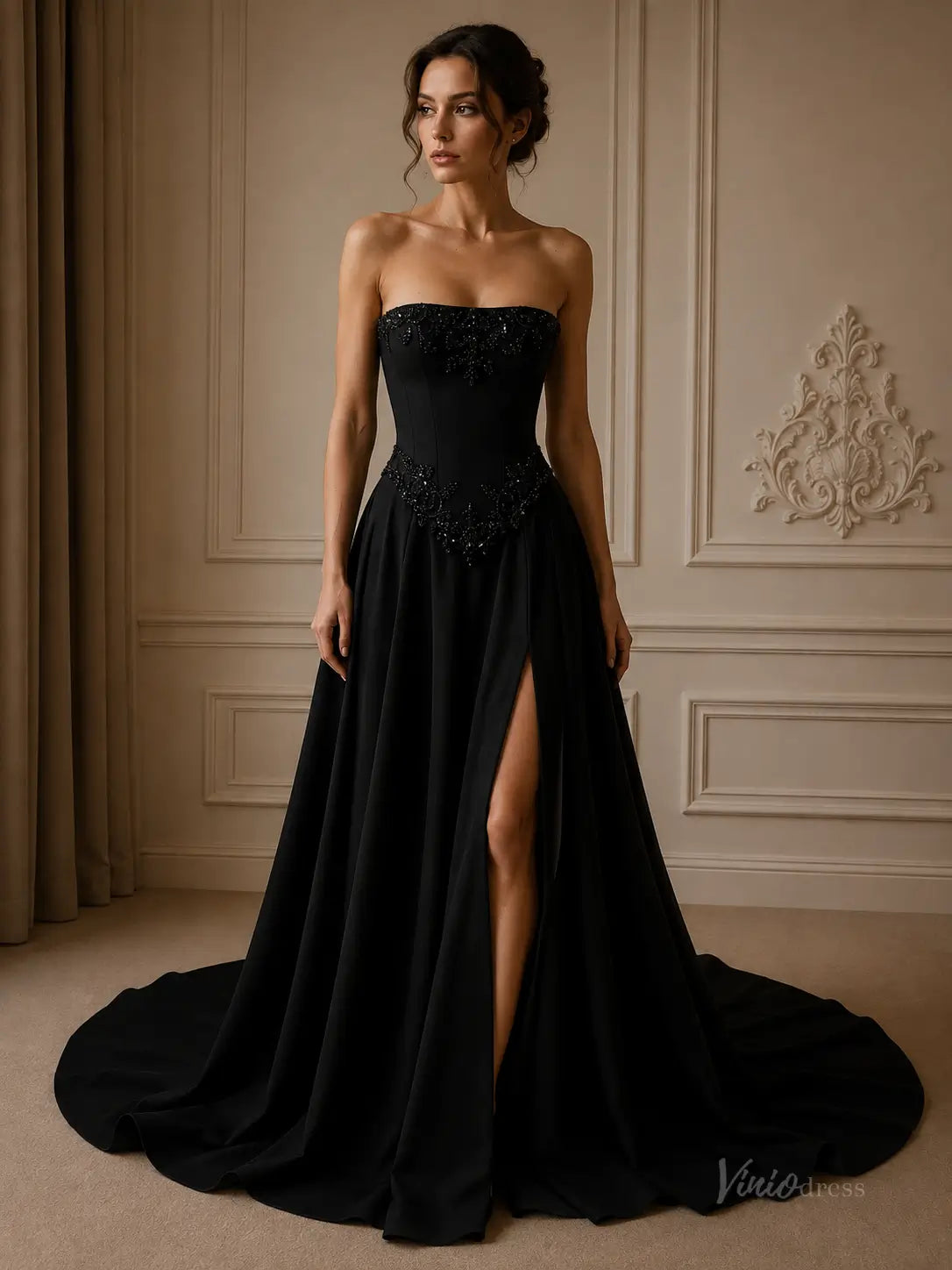 Black strapless crepe evening gown with a beaded corset bodice, high leg slit, and a dramatic floor-length train.