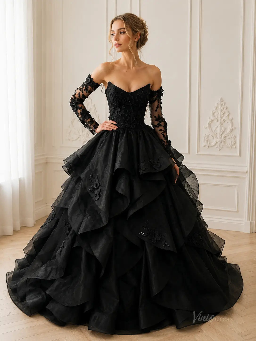 Black off-the-shoulder ball gown with long lace sleeves, floral embroidery, and a voluminous tiered organza skirt.