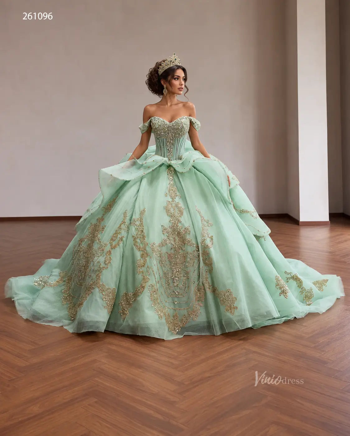 Mint green quinceanera ball gown with gold baroque embroidery, crystal corset, off-shoulder neckline, and tiered peplum.