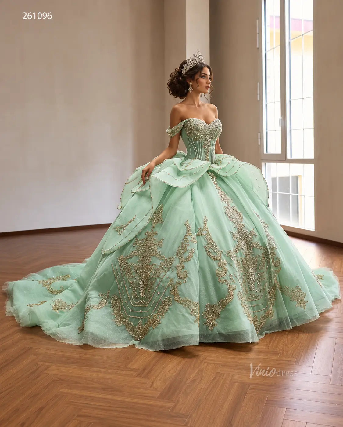 Mint green off-shoulder quinceañera ball gown with gold baroque embroidery, crystal corset, and tiered peplum skirt.