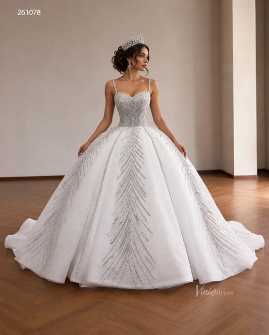 White quinceañera ball gown with a sequin corset bodice, spaghetti straps, and shimmering beaded leaf-pattern skirt.