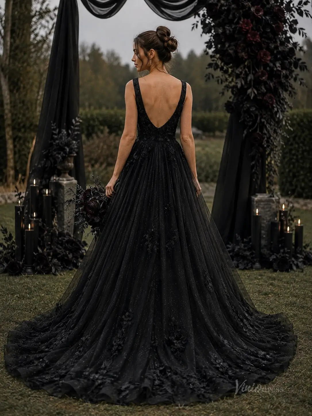 Black A-line wedding dress in glitter tulle with 3D floral appliqué, deep V-back, and a chapel train.