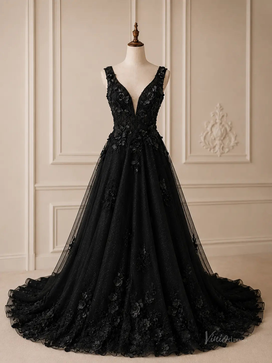 Black A-line wedding dress in glitter tulle with deep V-neck, 3D floral appliqué, and a chapel train on a mannequin.