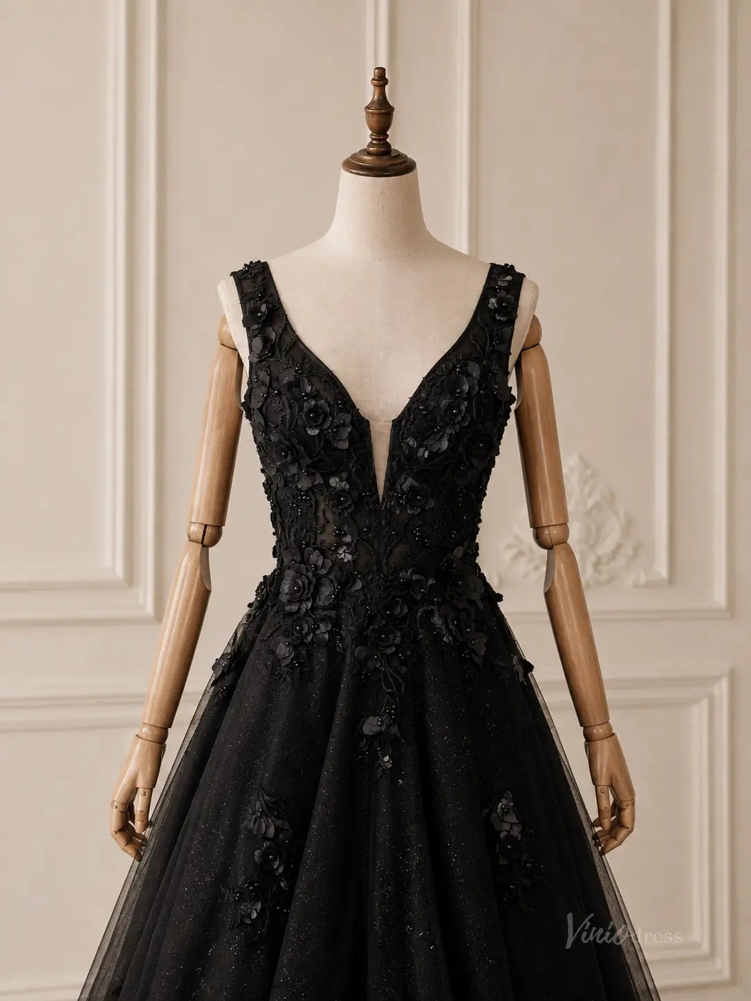 Black glitter tulle A-line wedding dress with deep V-neckline and 3D floral appliqué on a mannequin.