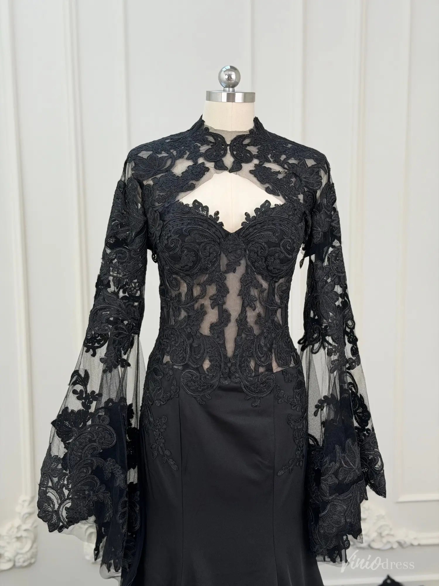 Black mermaid wedding dress with a detachable sheer lace long sleeve overlay and high neckline on a mannequin.
