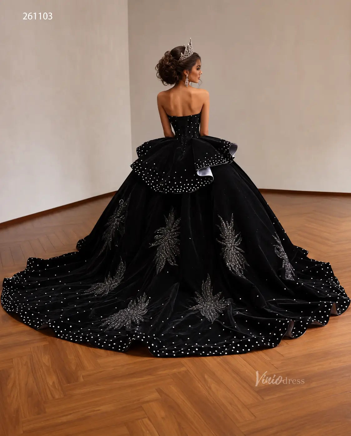 Black velvet quinceañera ball gown with crystal embellishments, beaded leaf embroidery, and a ruffled peplum skirt.