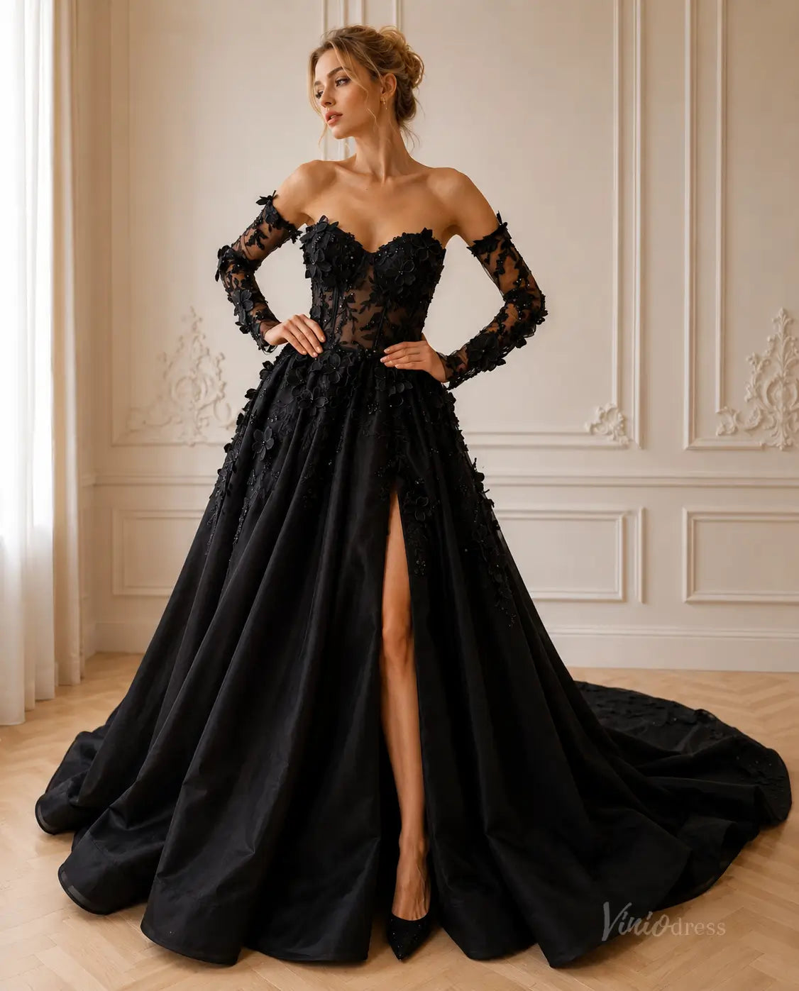 Black strapless ball gown with floral lace bodice, long sleeves, and a high-slit full skirt with a dramatic train.