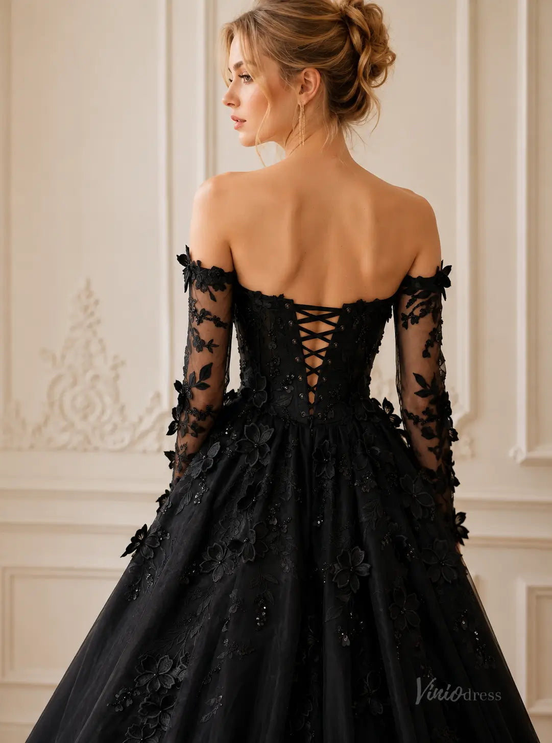 Black off-the-shoulder ball gown with long lace sleeves, floral appliques, and a corset-style lace-up back.