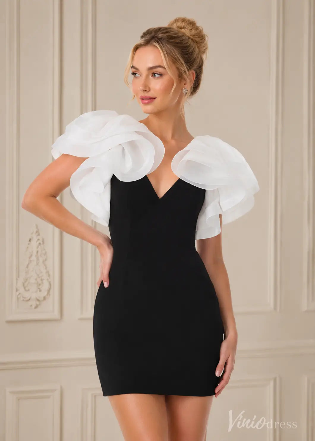 Black mini dress with white ruffled organza sleeves and a deep V-neckline, worn by a blonde woman.