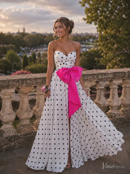Strapless white polka dot prom dress with a high slit and oversized hot pink satin waist bow.
