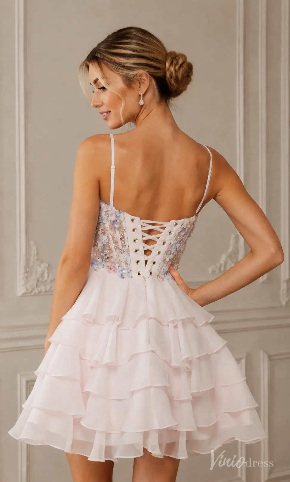 Light pink tiered ruffle mini dress with floral embroidered bodice and lace-up back.