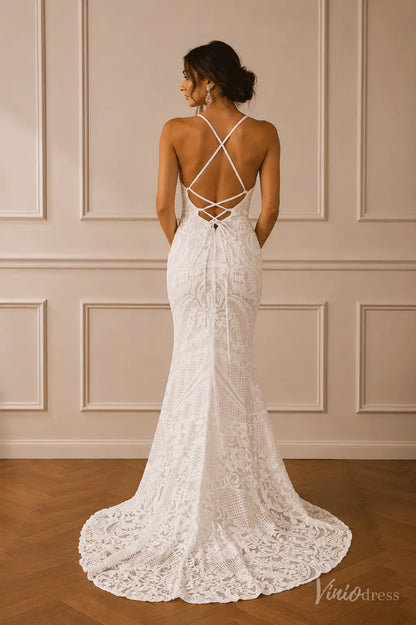 Boho mermaid wedding dress in white lace with spaghetti straps and a crisscross open back with a lace-trimmed train.