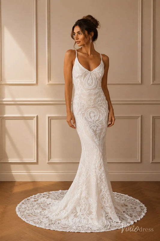 Boho mermaid wedding dress in white lace with a V-neckline, spaghetti straps, and a delicate lace-trimmed train.