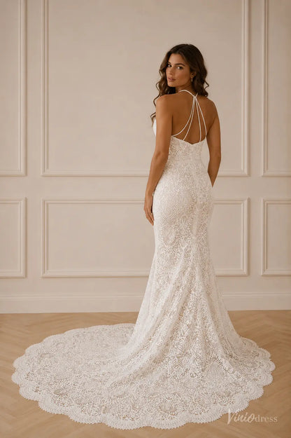 White lace mermaid wedding dress with a strappy open back and a long, elegant scalloped train.