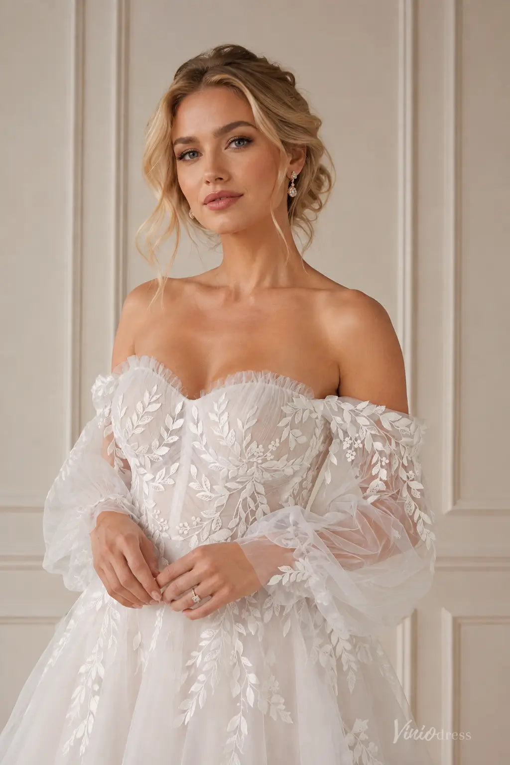 Boho wedding dress with pleated bodice, off-shoulder puff sleeves, and intricate white floral lace appliqués.