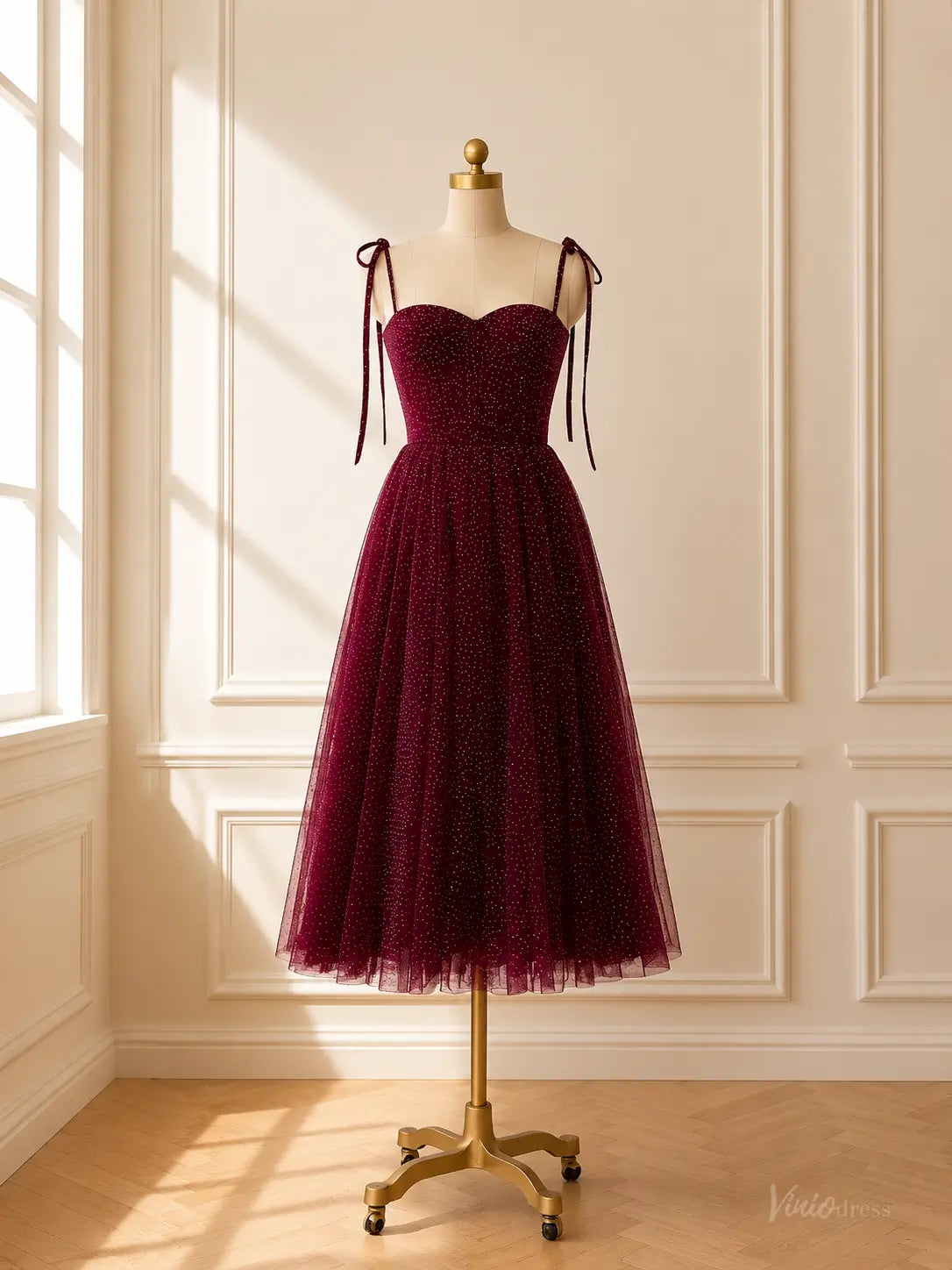 Burgundy tea-length prom dress in glitter tulle with a sweetheart neckline, corset bodice, and tie shoulder straps.