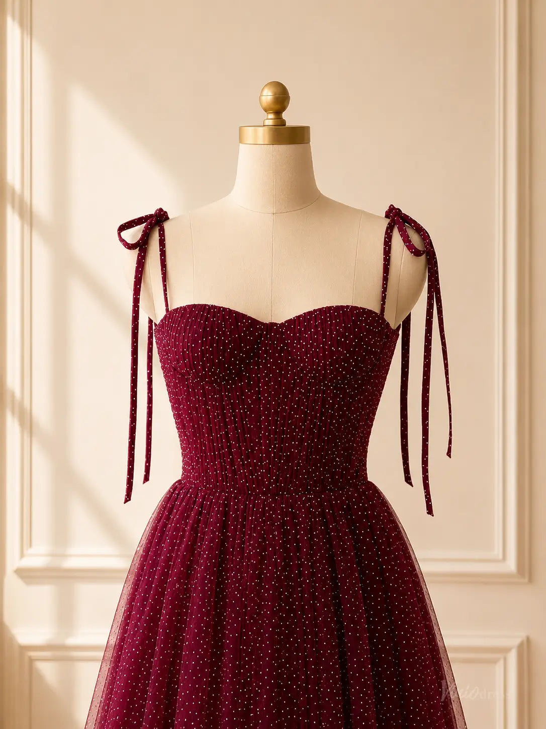 Burgundy tea-length prom dress in glitter tulle with a sweetheart neckline, corset bodice, and tie shoulder straps.