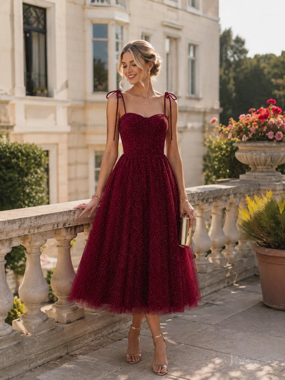 Burgundy tea-length prom dress in glitter tulle with a sweetheart neckline, corset bodice, and adjustable tie straps.