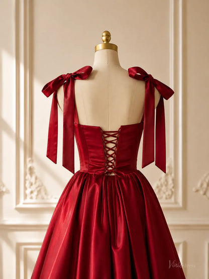 Burgundy satin ball gown with a lace-up corset back, bow shoulder straps, and a voluminous gathered skirt on a mannequin.