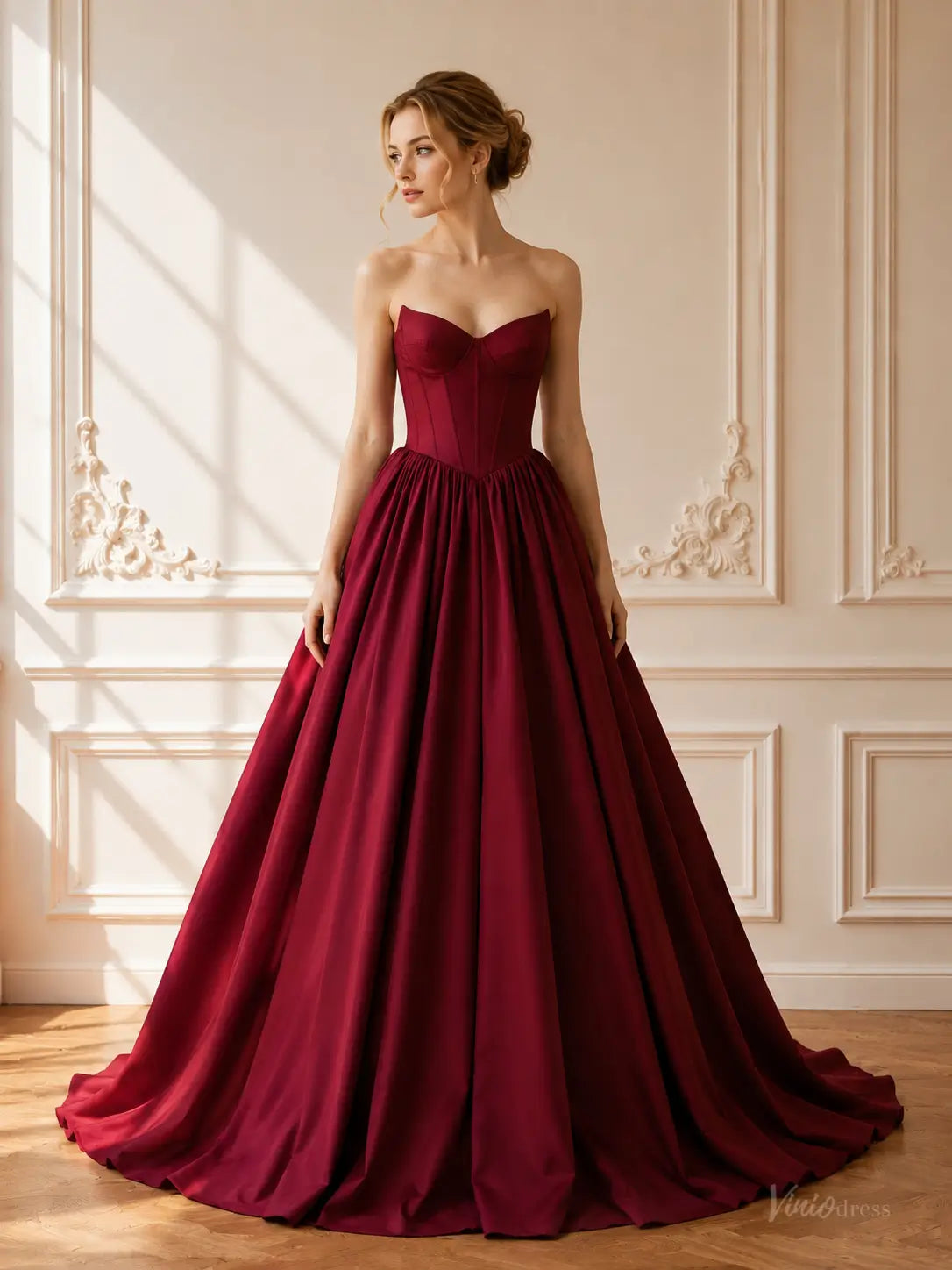 Burgundy satin ball gown with a strapless sweetheart corset bodice and a dramatic floor-length gathered skirt.