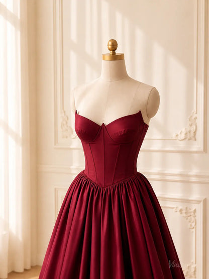Burgundy satin ball gown with a strapless sweetheart corset bodice and a flattering basque waist on a mannequin.