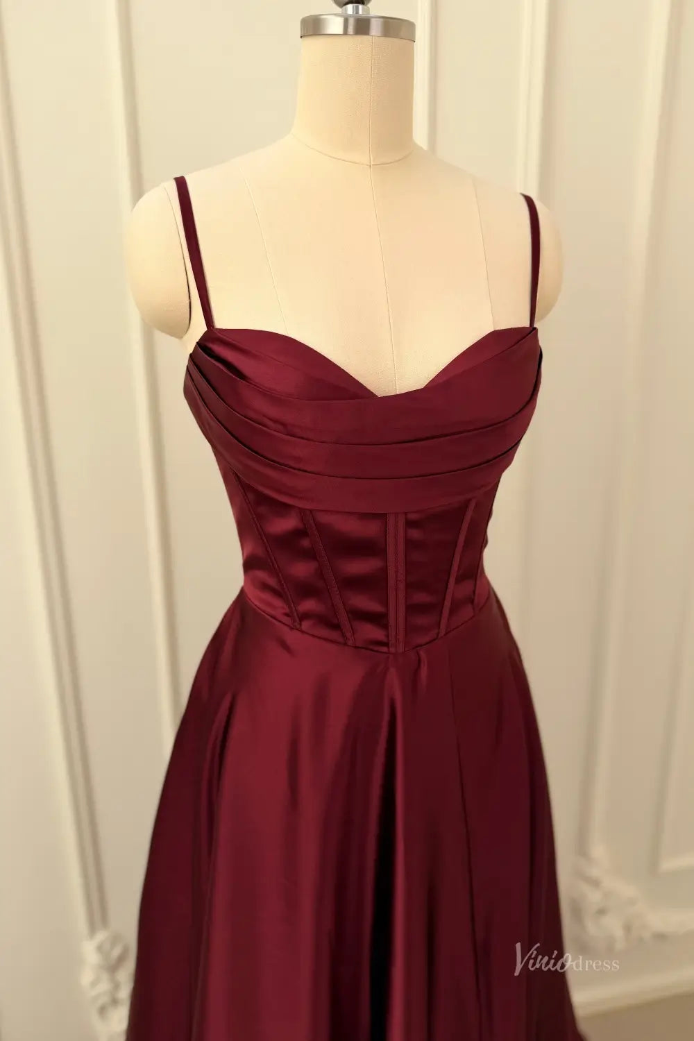 Burgundy satin prom dress with a pleated sweetheart neckline and structured corset bodice.