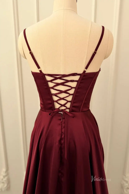 Lace-up back of a burgundy satin prom dress with spaghetti straps on a mannequin.