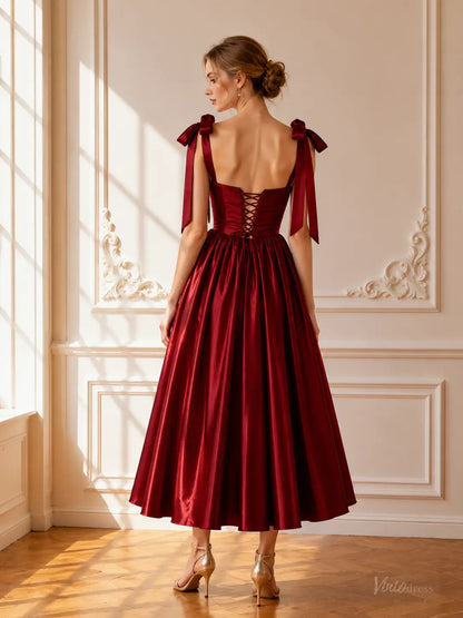Burgundy satin tea-length prom dress with a lace-up corset back and bow shoulder straps.