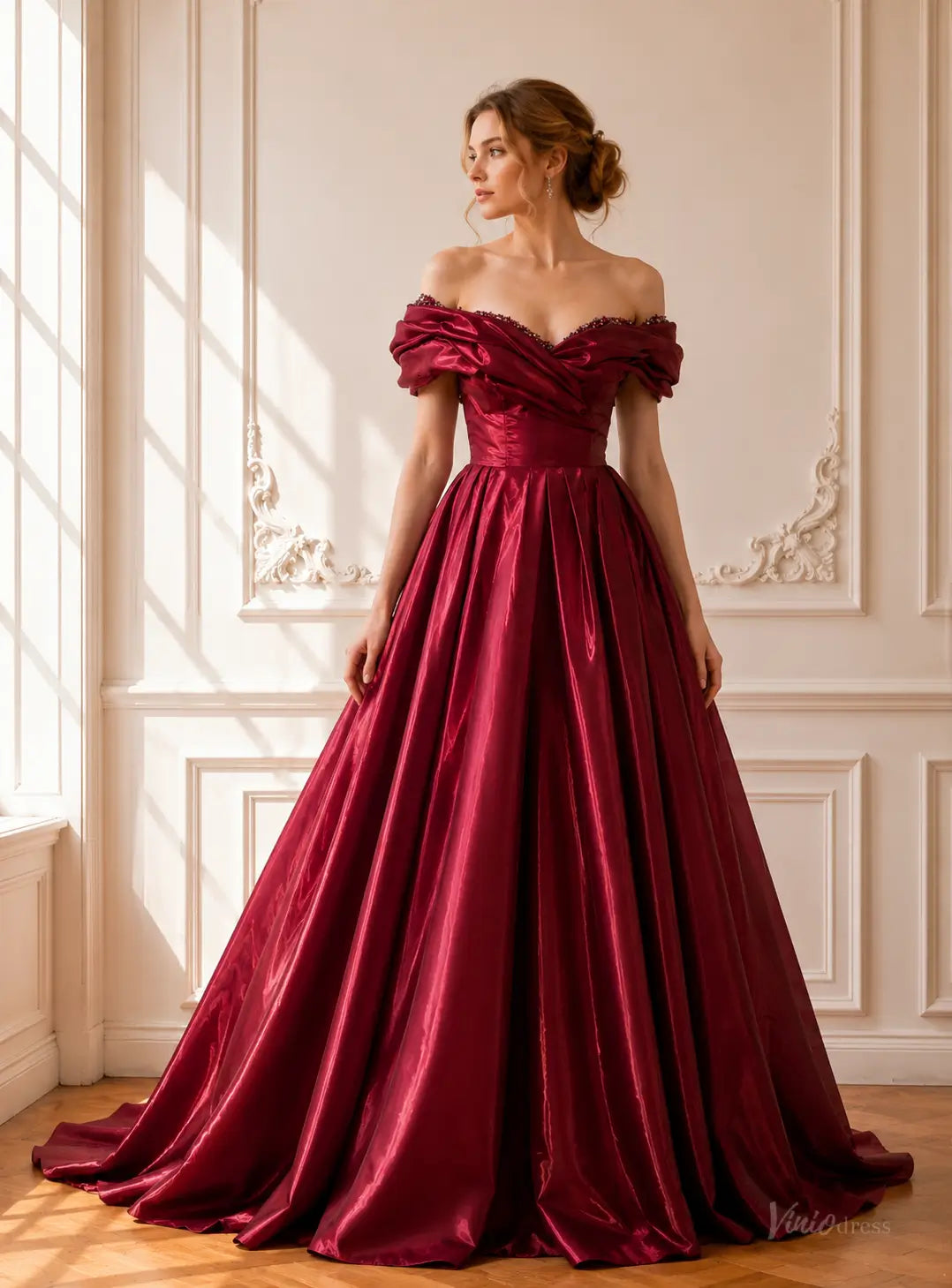Burgundy off-shoulder satin ball gown with a draped bodice, beaded neckline, and a voluminous pleated floor-length skirt.