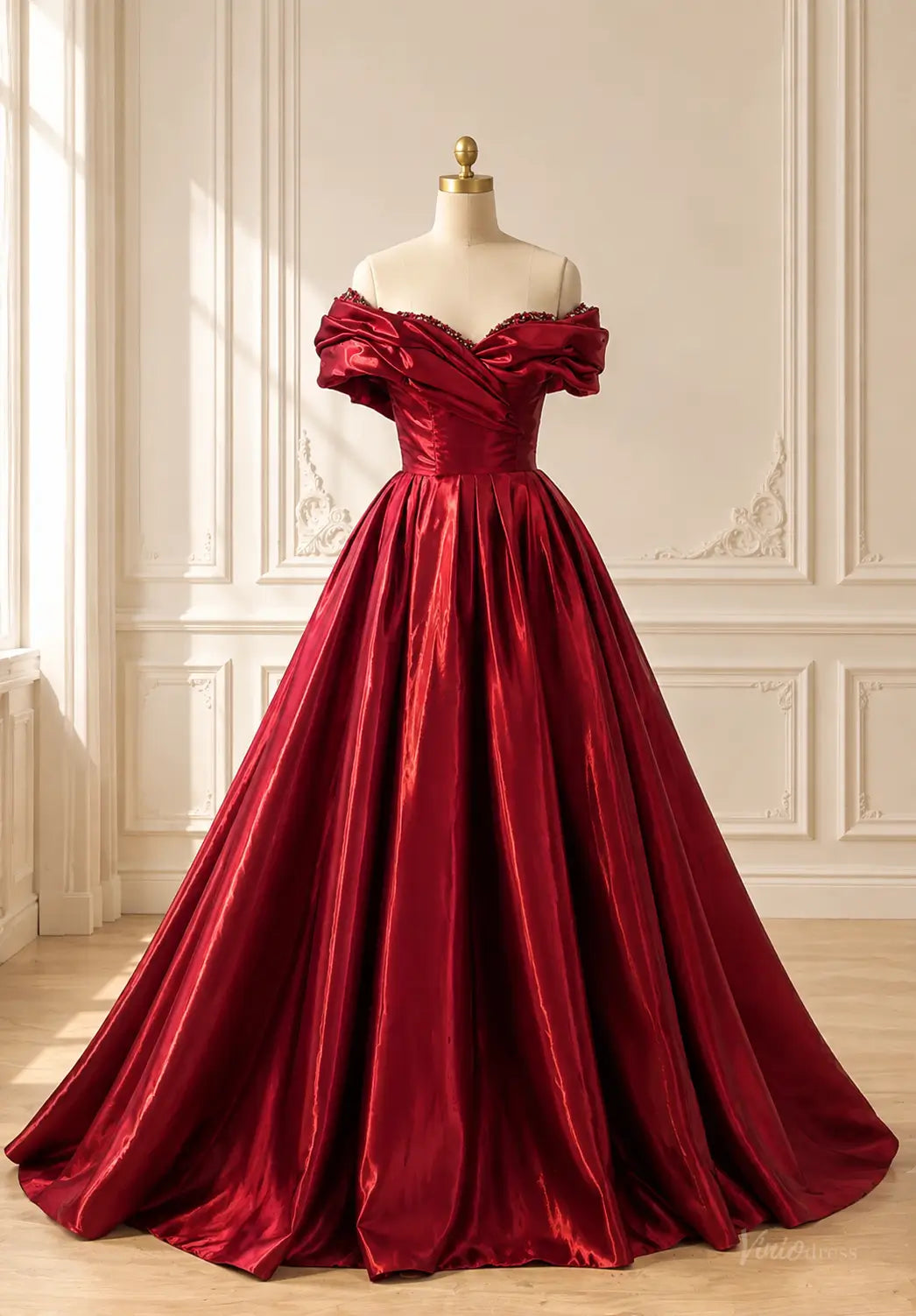 Burgundy satin ball gown with off-shoulder draped bodice and beaded neckline on a mannequin.