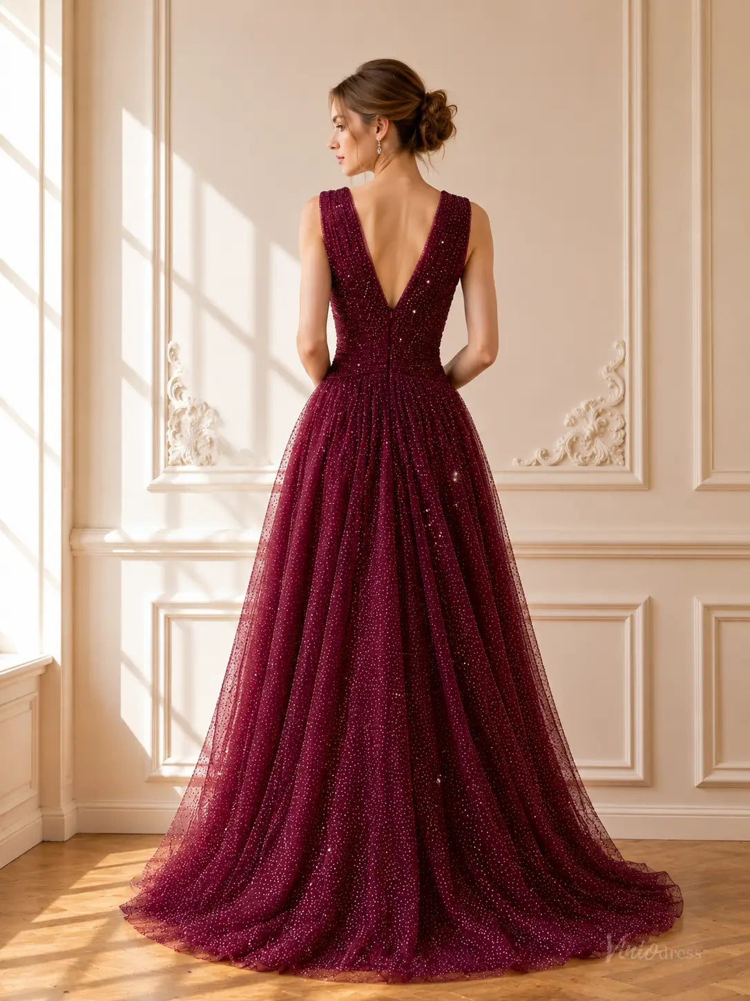 Burgundy sparkly tulle A-line prom dress with a deep V-back, sleeveless bodice, and floor-length flowing skirt.
