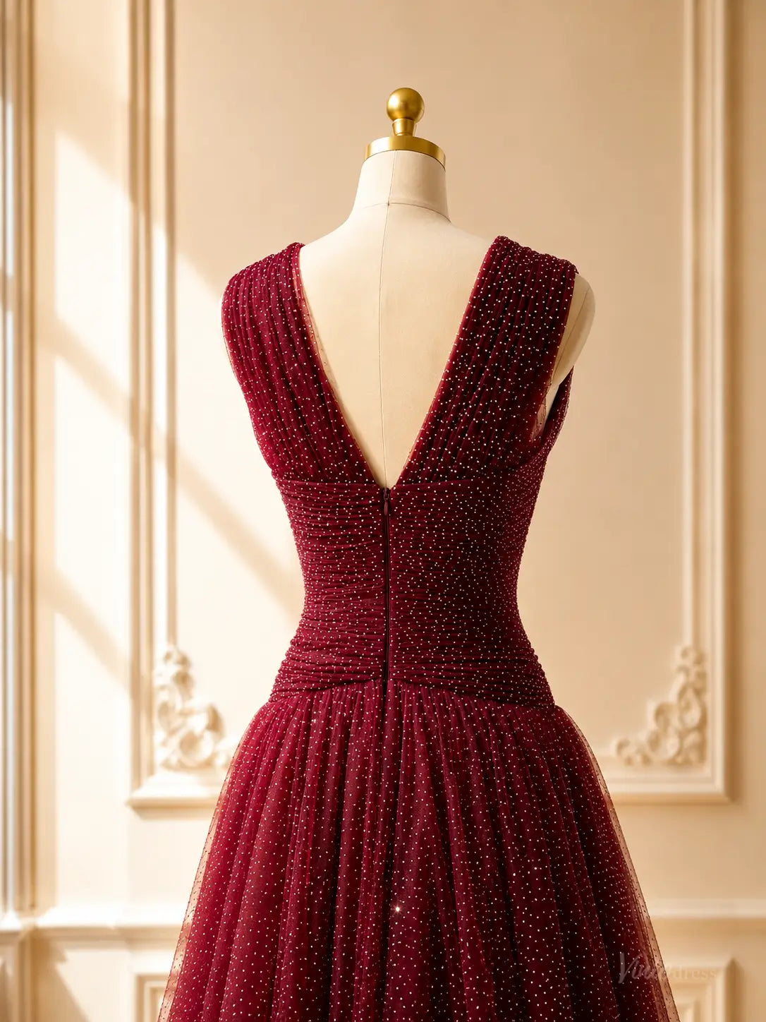 Burgundy sparkly tulle prom dress with a deep V-back, ruched bodice, and flowing A-line skirt on a mannequin.