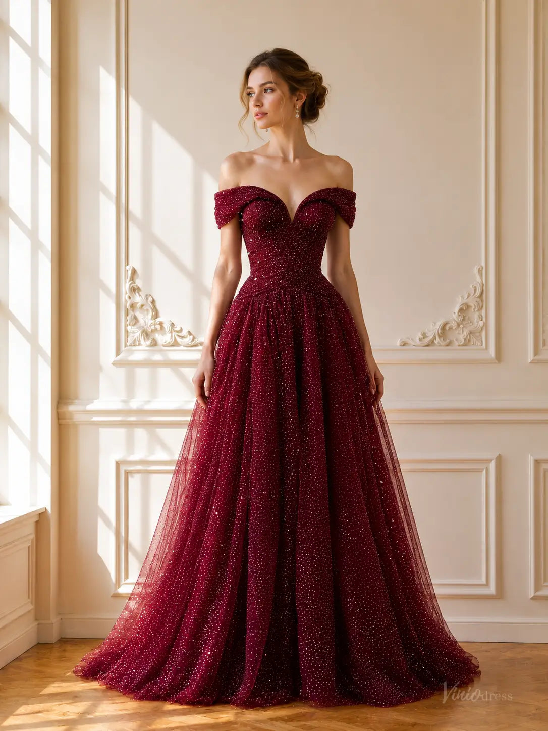 Burgundy sparkly tulle ball gown with an off-shoulder sweetheart neckline and a voluminous floor-length skirt.