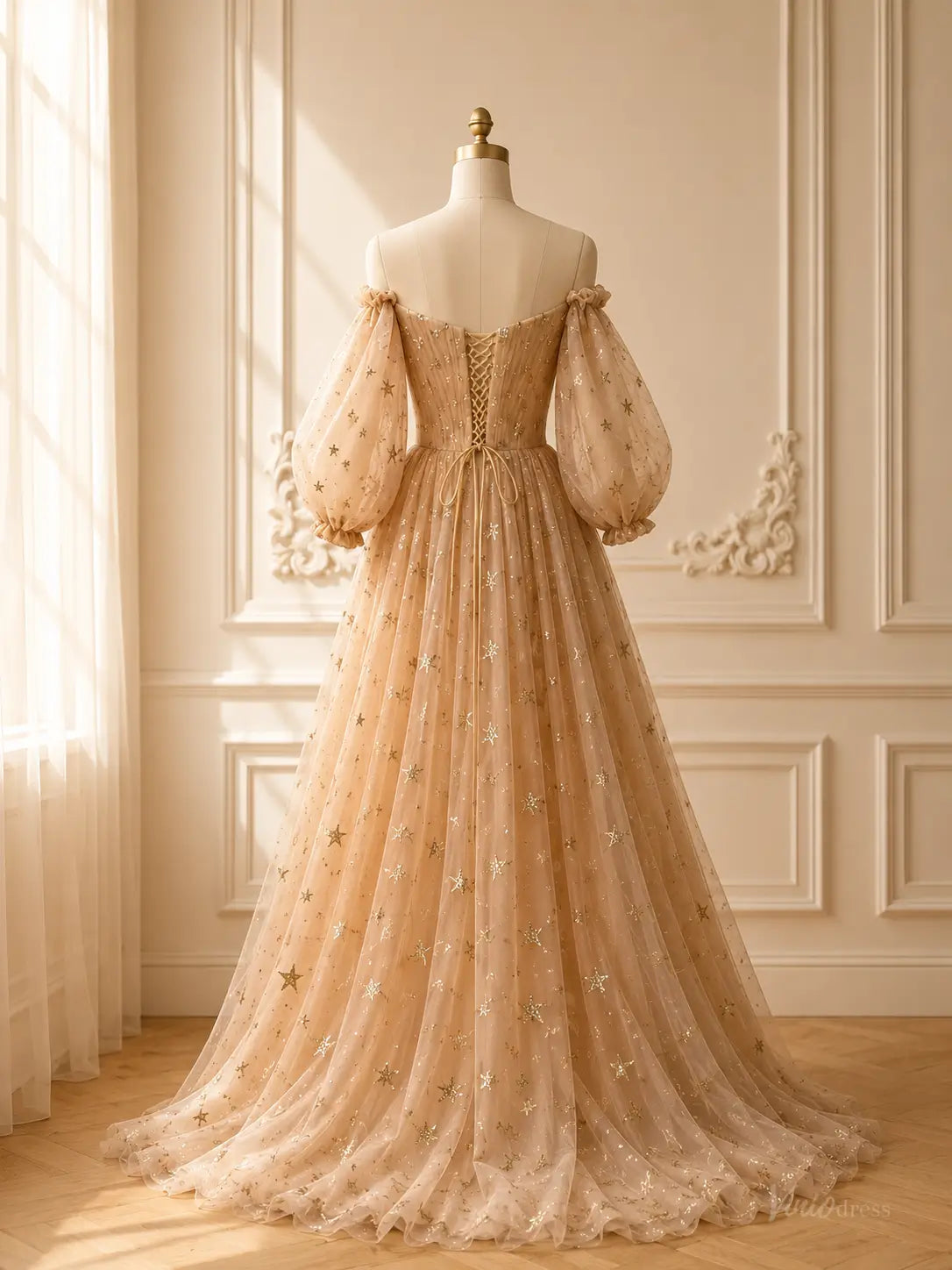 Champagne tulle prom dress with gold star patterns, puff sleeves, and a lace-up corset back on a mannequin.