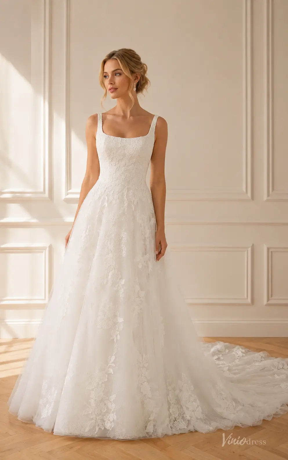 White A-line wedding dress with a square neckline, floral lace bodice, and a flowing tulle skirt with a train.