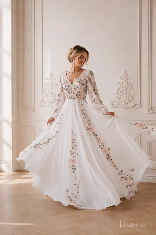 A-line chiffon wedding dress with long sleeves, V-neck, and blush floral embroidery on an ivory gown.