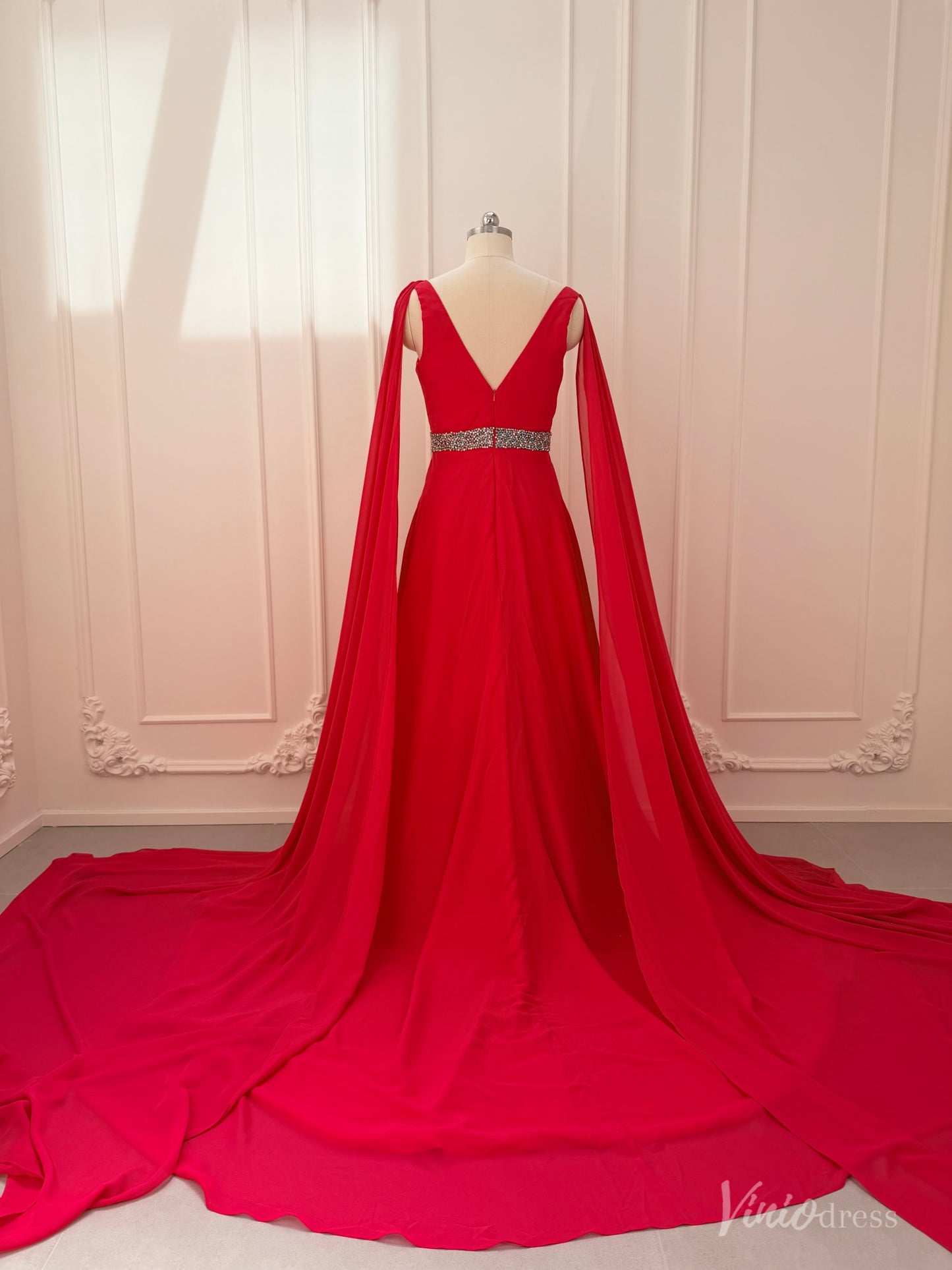 Crimson red chiffon A-line gown with V-neck, dramatic cape sleeves, and a beaded waistline on a mannequin.
