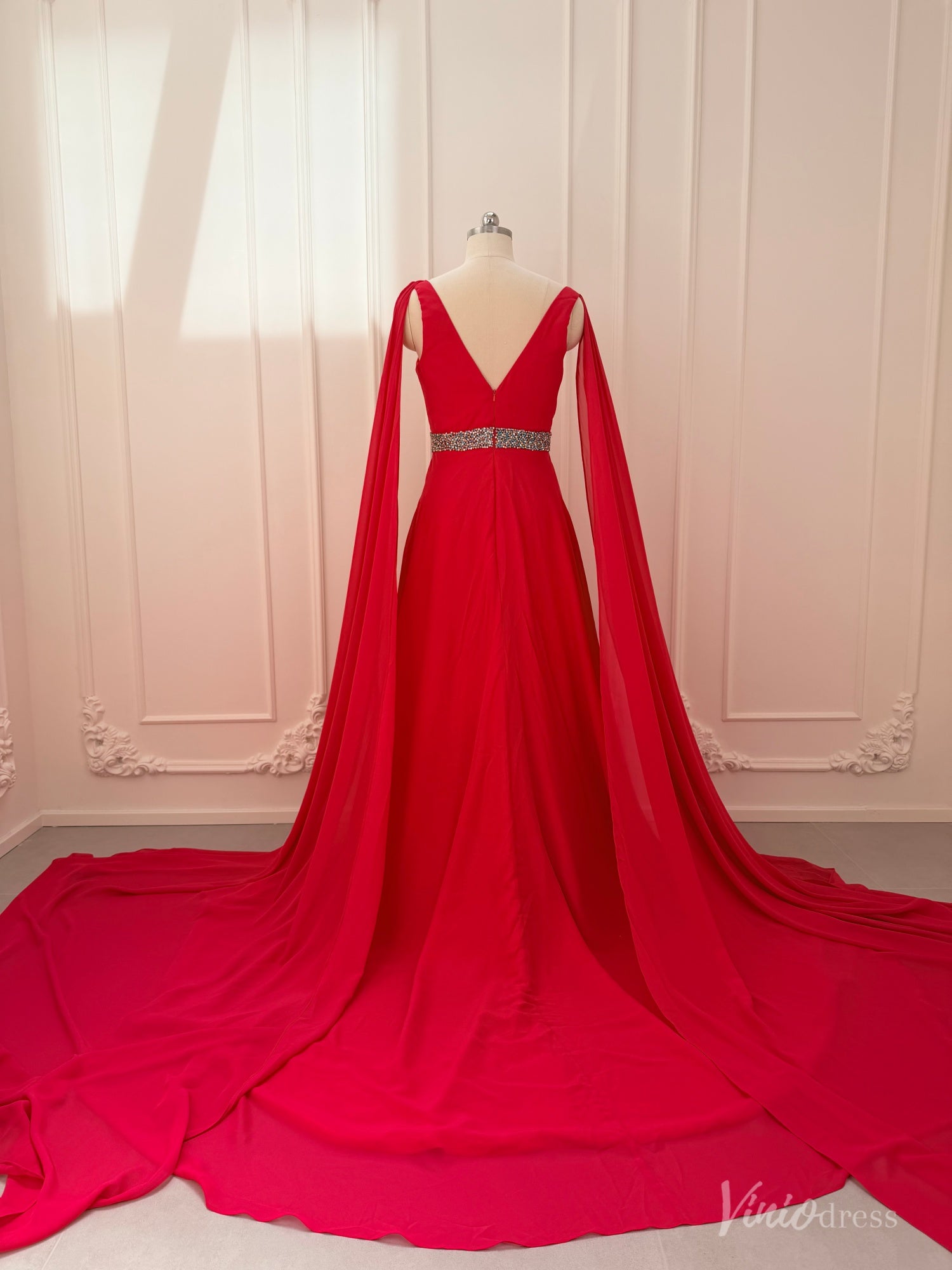 Crimson red chiffon A-line gown with V-neck, dramatic cape sleeves, and a beaded waistline on a mannequin.