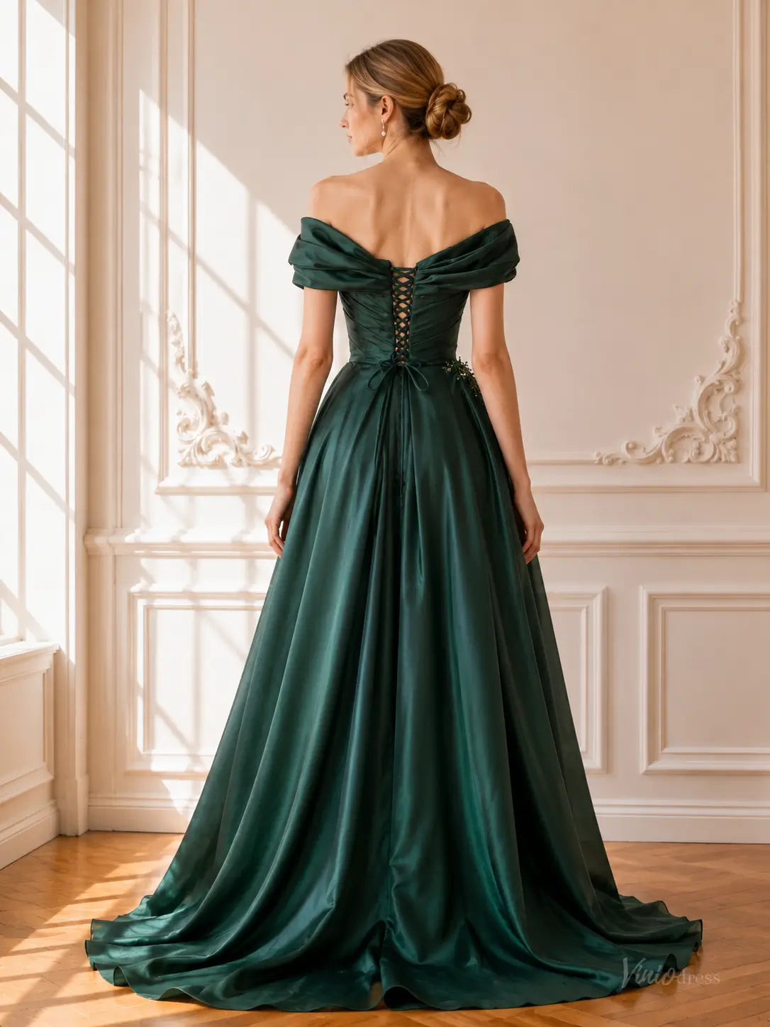 Emerald green satin prom dress with off-shoulder draping, a lace-up corset back, and a flowing A-line skirt.