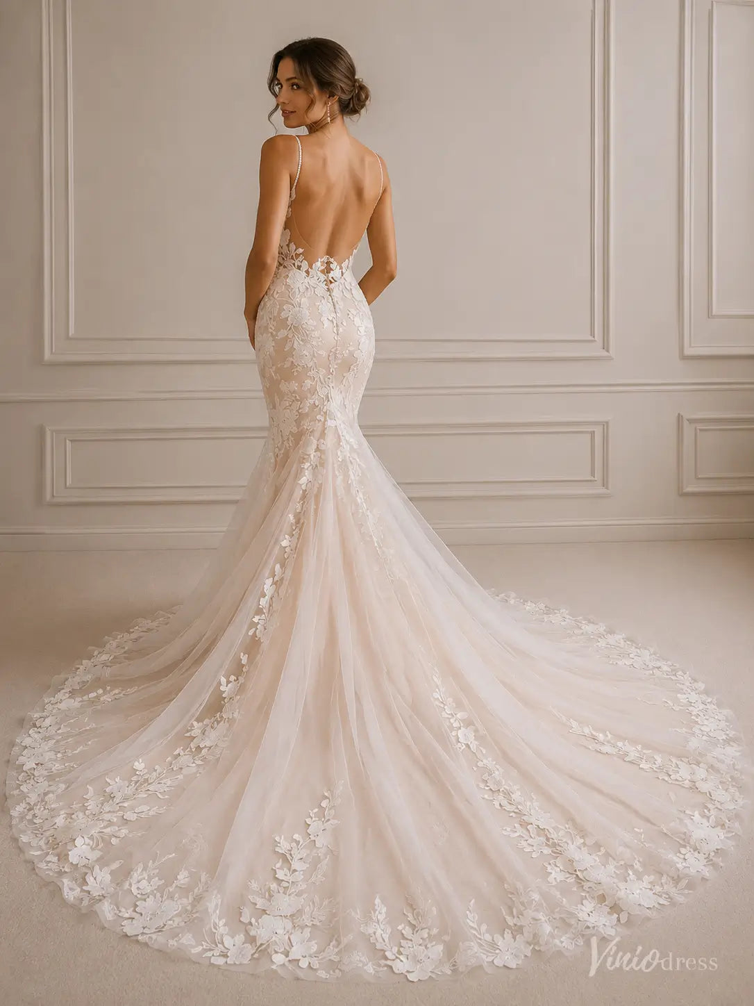 Back view of an ivory 3D floral lace mermaid wedding dress with a low back, spaghetti straps, and a lace-embroidered train.