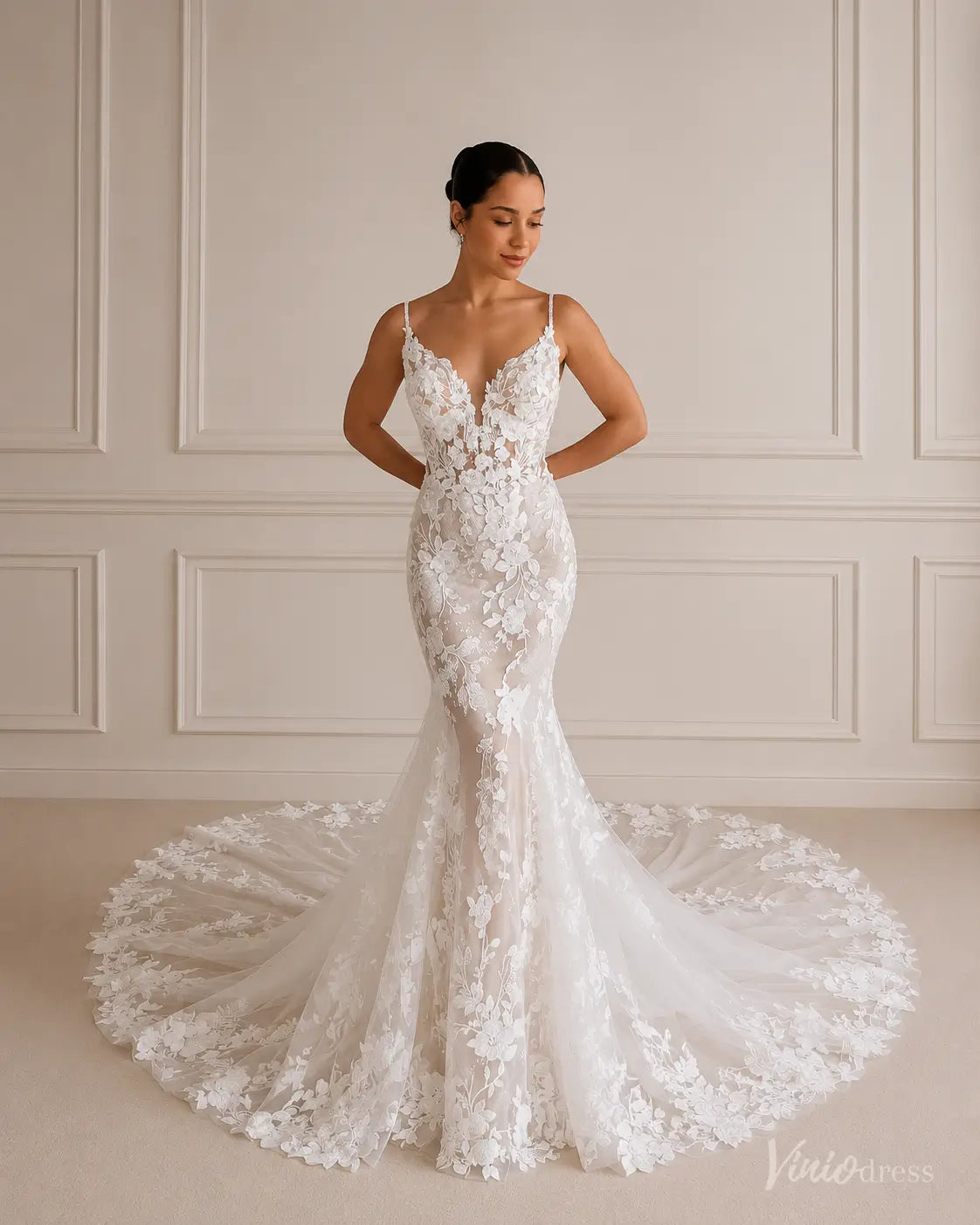 Ivory mermaid wedding dress with 3D floral lace, deep V-neckline, spaghetti straps, and a sheer corset bodice with a train.