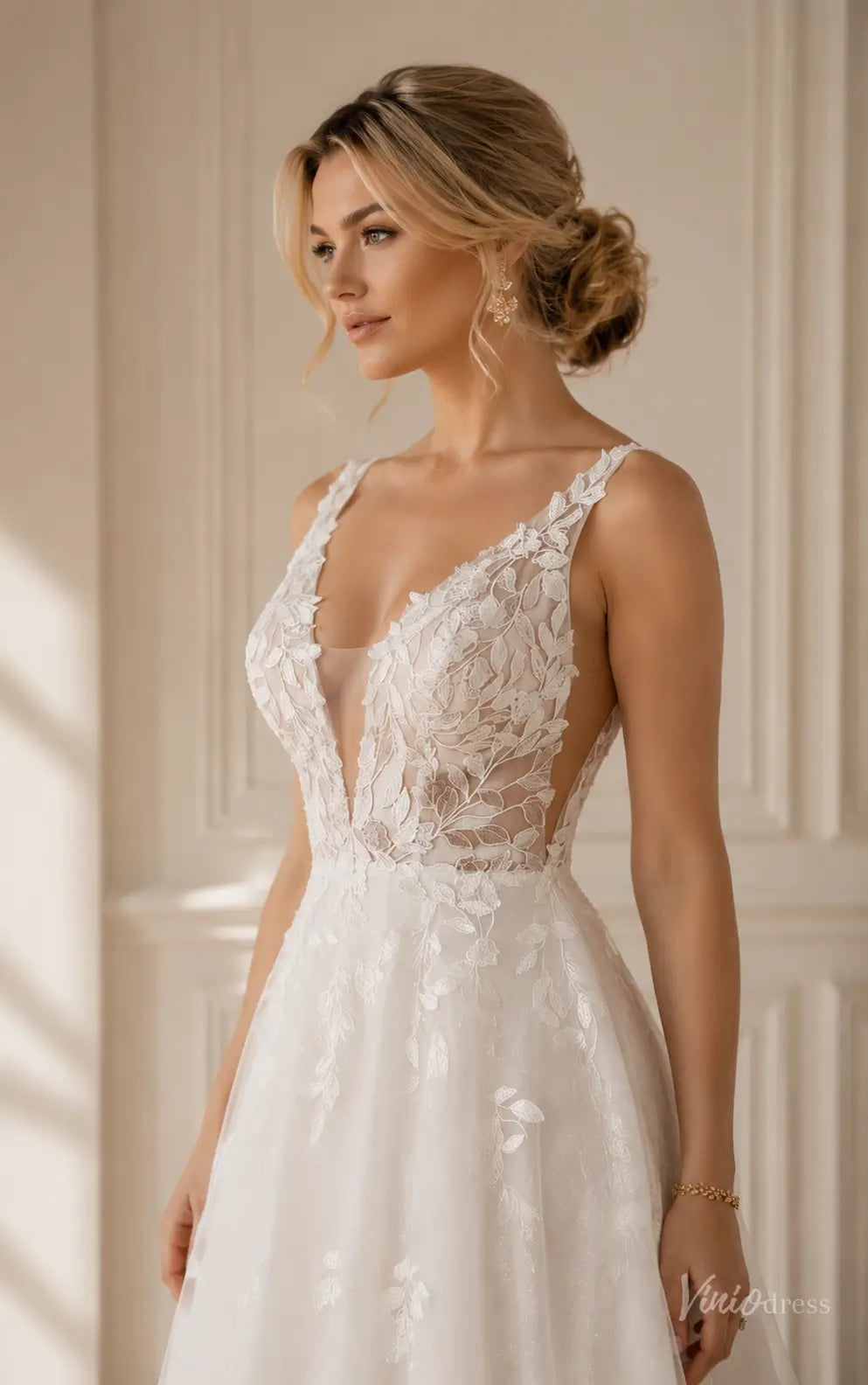 A-line wedding dress with a deep V-neck, sheer lace floral appliqué bodice, and spaghetti straps in white tulle.