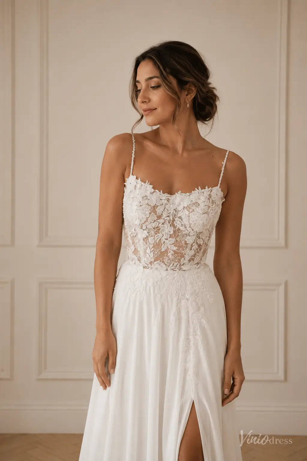 White chiffon wedding dress with a sheer lace bodice, spaghetti straps, and a high leg slit.