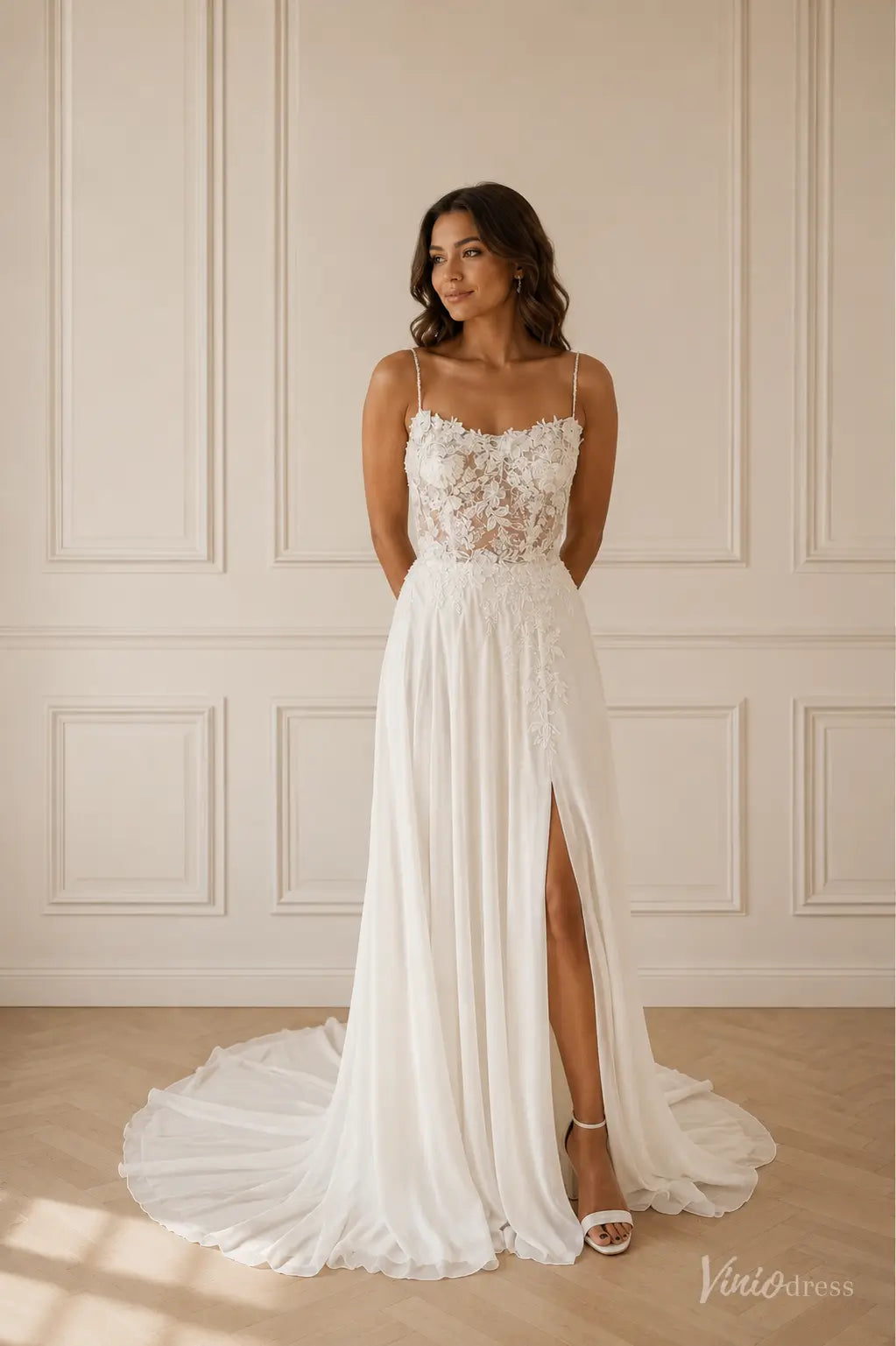 White chiffon wedding dress with a floral lace bodice, spaghetti straps, and a high side slit with a flowing train.